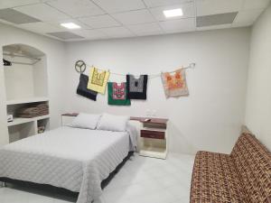瓦哈卡市Hermosa Hacienda Las Heliconias的卧室配有挂在墙上的床和毛巾。