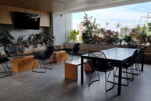 危地马拉Apartamento Granat cerca del aeropuerto y la zona cultural y gastronómica的配有桌椅和植物的房间