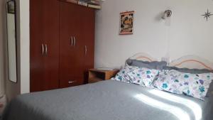 El CarmenLa Nona的一间卧室配有一张床和一个木制橱柜