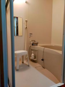 田边市民宿 和合 Minshuku WAGO的一间带凳子和浴缸的浴室
