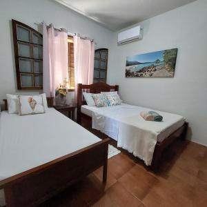 阿拉夏奇巴海滩Espaço Villa Ará的一间卧室设有两张床和窗户。