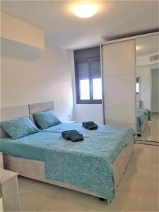 提比里亚4bdrm - 110mr - Dream vacation apartment的一间卧室配有一张带蓝色床单和镜子的床