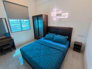 芙蓉Homestay Naufal Bandar Sri Sendayan Ground Floor的一间卧室配有蓝色的床和电视