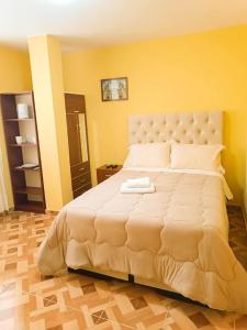 利马Pretty room in front of the Lima Airport的一张白色的大床,位于拥有黄色墙壁的房间