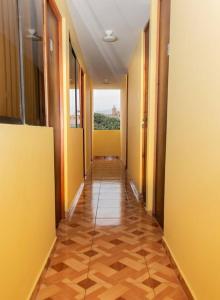 利马Pretty room in front of the Lima Airport的走廊设有黄色的墙壁和瓷砖地板