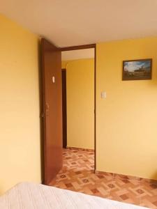 利马Pretty room in front of the Lima Airport的一间卧室设有黄色的墙壁和一扇带镜子的门