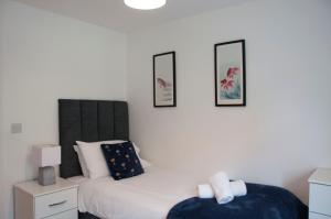 沃特福德Watford Gemini Hurst的卧室配有一张床,墙上挂有两张照片