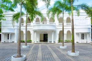 本托塔保格别墅酒店的一座白色的建筑,前面有棕榈树