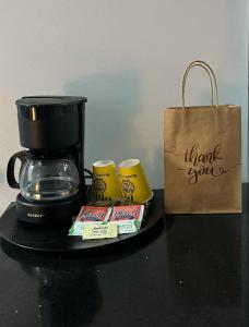 CareneroSuites Bocas del Toro的咖啡壶和桌子上的纸袋
