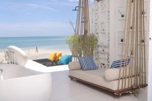 恰洛克拉姆Adika - The beachfront Loft的一个带吊床的门廊,享有海滩美景