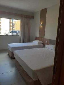 卡达斯诺瓦斯Praias do Lago Eco Resort的配有窗户的酒店客房内的两张床