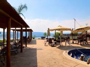 卡达斯诺瓦斯Praias do Lago Eco Resort的一个带桌子和遮阳伞的庭院和一个游泳池