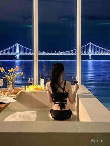 釜山Stay moment的坐在柜台上看着桥的女人