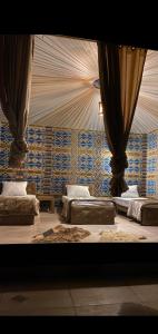 瓦迪拉姆Rum Under The Stars Camp的一间设有三张床的客房,墙上挂着窗帘