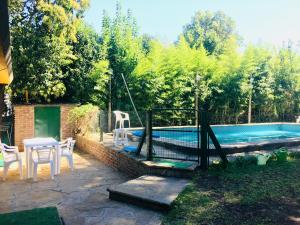 贝纳维德斯Casa Quinta Tigre Benavidez的后院设有游泳池、桌子和椅子