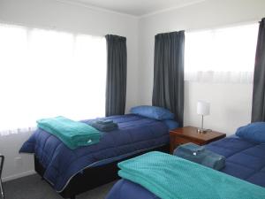 WairoaThe Mitch的一间卧室配有两张蓝色床单
