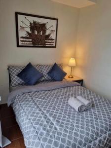 马尼拉Casa REYNA at KASARA Urban Residences的一间卧室配有一张带蓝色枕头的大床