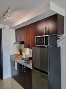 马尼拉Casa REYNA at KASARA Urban Residences的厨房配有冰箱上方的微波炉