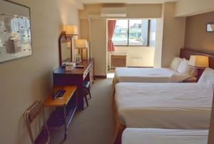 东京泽姆城市旅馆的酒店客房配有两张床和一张书桌