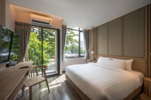 曼谷SHAN Villas Sukhumvit的一间卧室配有一张床、一张书桌和一台电视