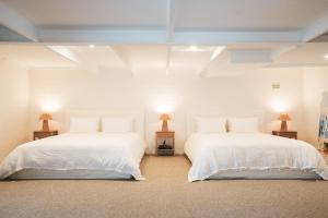 拜伦湾Wategos Villa的配有2张床的白色墙壁和2盏灯。