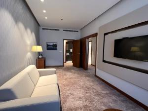 莫斯塔尔米帕斯酒店的客厅配有白色沙发和平面电视。