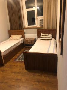 库塔伊西Hotel Nikea Paradiso的一间卧室设有两张床和窗户。