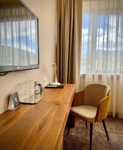 莫斯塔尔米帕斯酒店的客房设有带椅子的木桌和窗户。