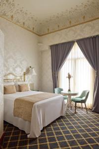 巴塞罗那洲际大厦酒店的一间卧室配有一张大床和一张桌子