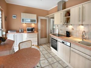 米尔豪森Ferienwohnungen Haus Angela的厨房配有白色橱柜、桌子和水槽。