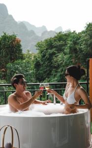 考索Phu Siab Mhok@KhaoSok的男人和女人坐在浴缸里,喝杯酒