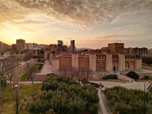 萨拉戈萨La balconada de la Aljafería con parking privado的一座大建筑,背景是一座城市