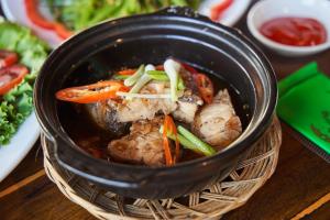 Vĩnh ThạnhHodota Cam Bình Resort & Spa - Lagi Beach的一大碗蔬菜和肉的黑碗食物