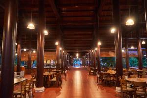 Vĩnh ThạnhHodota Cam Bình Resort & Spa - Lagi Beach的用餐室配有桌椅和灯光