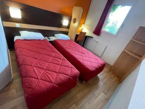 朗吉斯普瑞米尔奥利伦吉经典酒店的小房间设有两张床铺和红色毯子