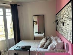 里昂红十字山酒店的粉红色的卧室配有床和镜子