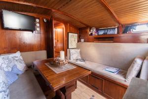 巴里Quo Vadis Yacht的火车上的用餐室,配有桌子和电视