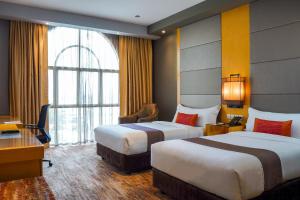 古晋古晋海滨酒店的酒店客房设有两张床和窗户。