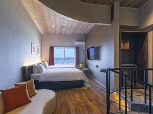 名户TWIN LINE HOTEL YANBARU OKINAWA JAPAN Formerly Okinawa Suncoast Hotel的酒店客房,配有床和沙发