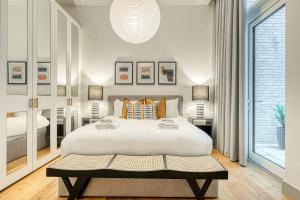 伦敦JOIVY Luxury flats near Big Ben and London Eye的一间卧室设有一张大床和一个大窗户