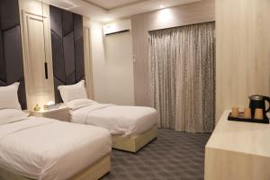 艾卜哈فندق المساء的酒店客房设有两张床和窗户。