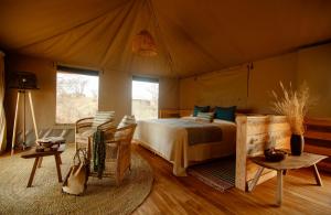 OlmotoniOlkeri Camp的帐篷内一间卧室,配有一张床