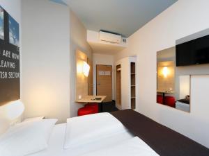 柏林柏林夏洛滕堡酒店的卧室配有白色的床和电视