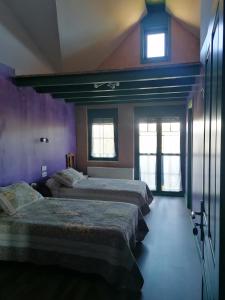 Murias de Rechivaldo弗洛尔旅馆的紫色墙壁和窗户的客房内的两张床