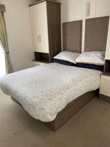 纽顿2 Bedroom Lodge - Honeysuckle 95, Trecco Bay的一间卧室配有两张床和橱柜