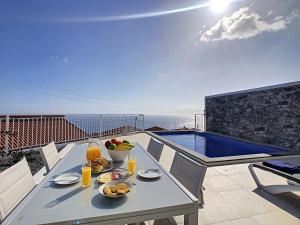 卡列塔Casa dos Amores by LovelyStay的一个带游泳池的阳台,配有一张桌子,上面摆放着食物和饮料