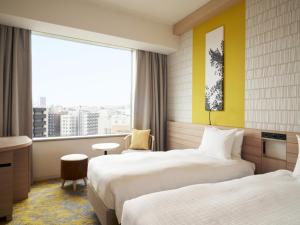 札幌札幌王子酒店的酒店客房设有两张床和窗户。