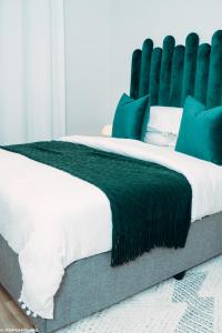 约翰内斯堡Green with Envy-Luxury Apartment- No Loadshedding的一间卧室配有一张带绿色床头板的床