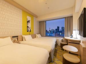 札幌札幌王子酒店的酒店客房设有两张床和大窗户。