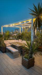 卡塔尼亚Follow The Sun Catania - Rooftop Terrace的天井设有桌子、长椅和植物